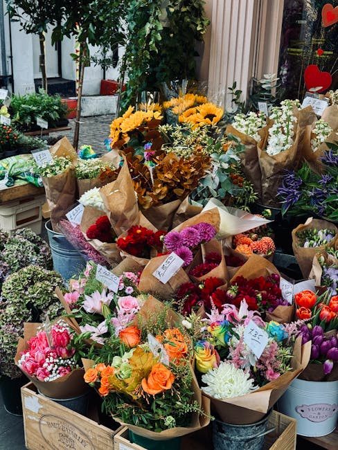A vibrant display of freshly arranged floral bouquets at a flower shop on Amersham Road Chesham. The arrangements include a variety of flowers such as pink lilies, orange roses, white chrysanthemums, 